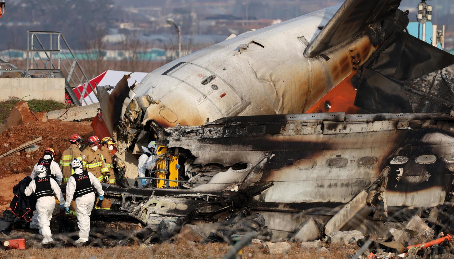 Los bomberos trabajan en los restos del avión Jeju Air en el Aeropuerto Internacional de Muan.