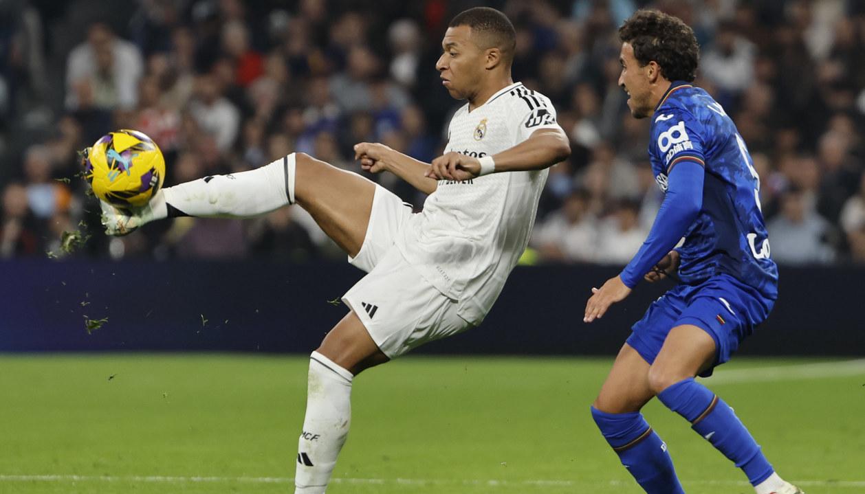 Kylian Mbappé intenta dominar el balón con la marca de Luis Milla.