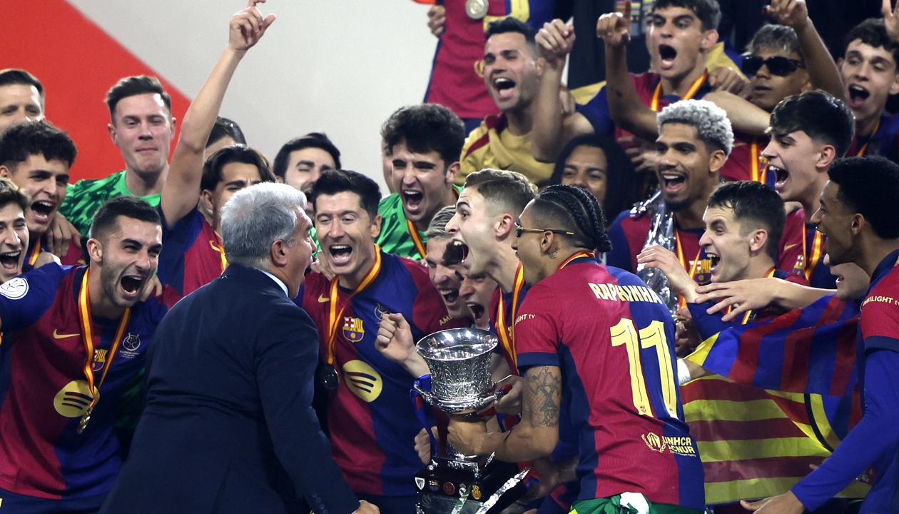 El presidente del FC Barcelona Joan Laporta, los jugadores y cuerpo técnico celebran la victoria con el trofeo