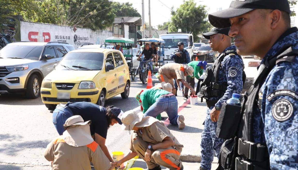 Privados de la libertad realizando labores de pintura en la calle 17. 