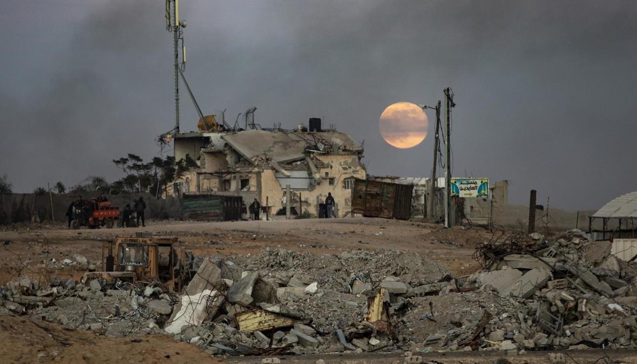 Supervivientes de los bombardeos israelíes huyendo de edificios destruidos en el sur de Gaza.