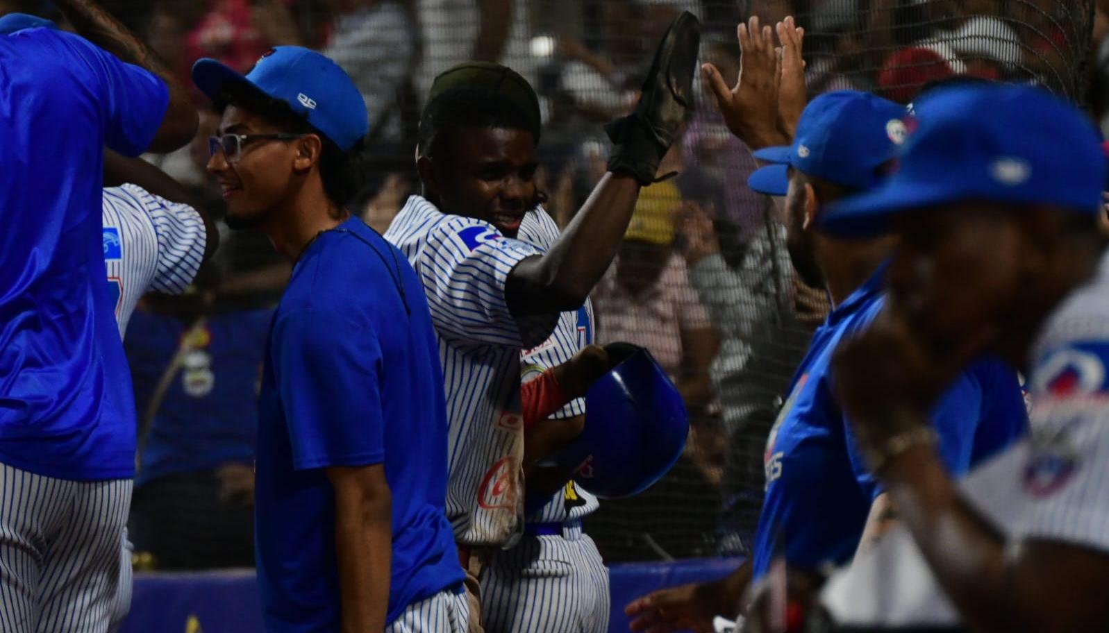 Édgar Barrios es felicitado en el dugout tras anotar la quinta carrera de Caimanes. 