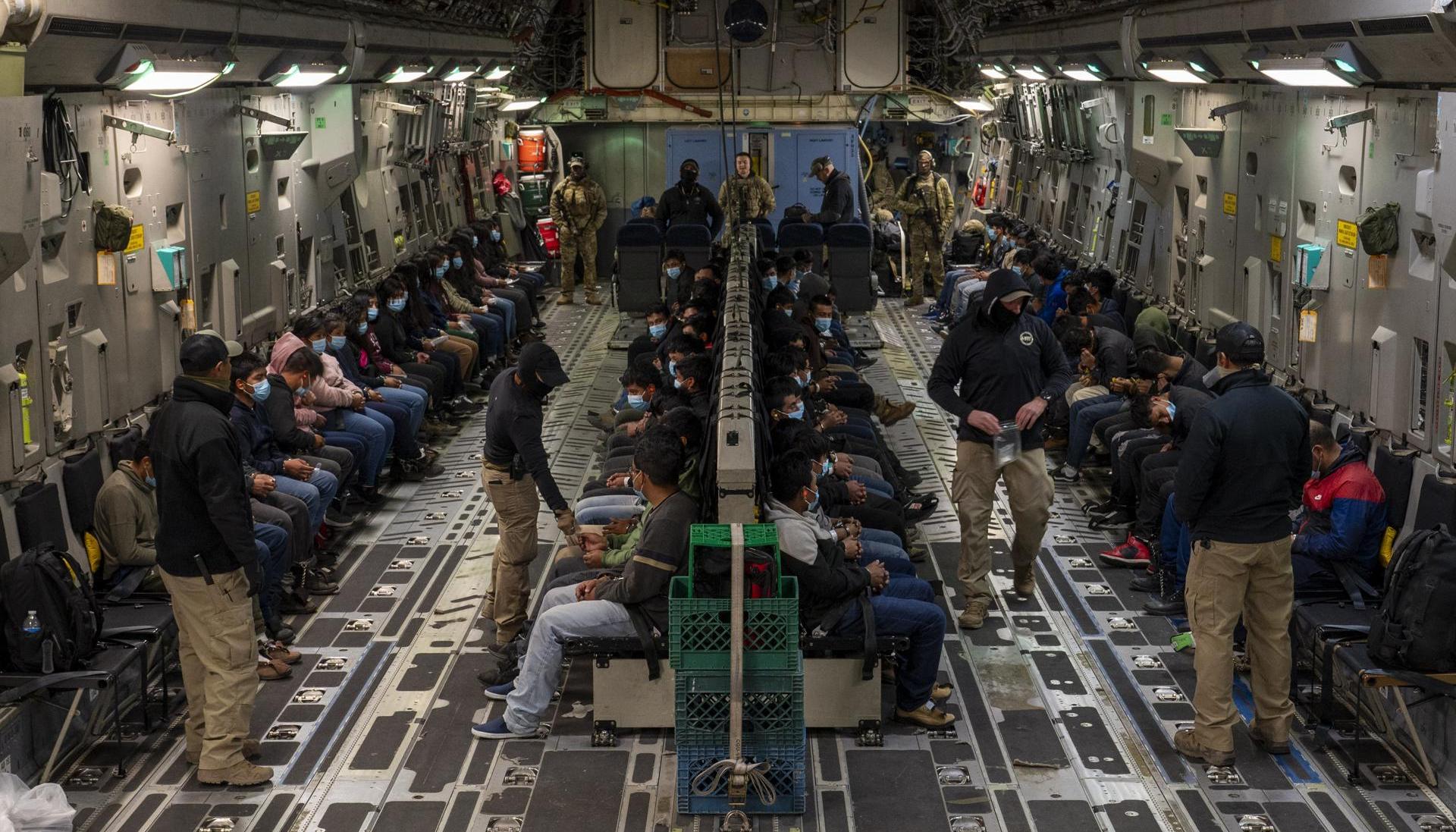 Indocumentados dentro de un avión militar norteamericano camino a su deportación
