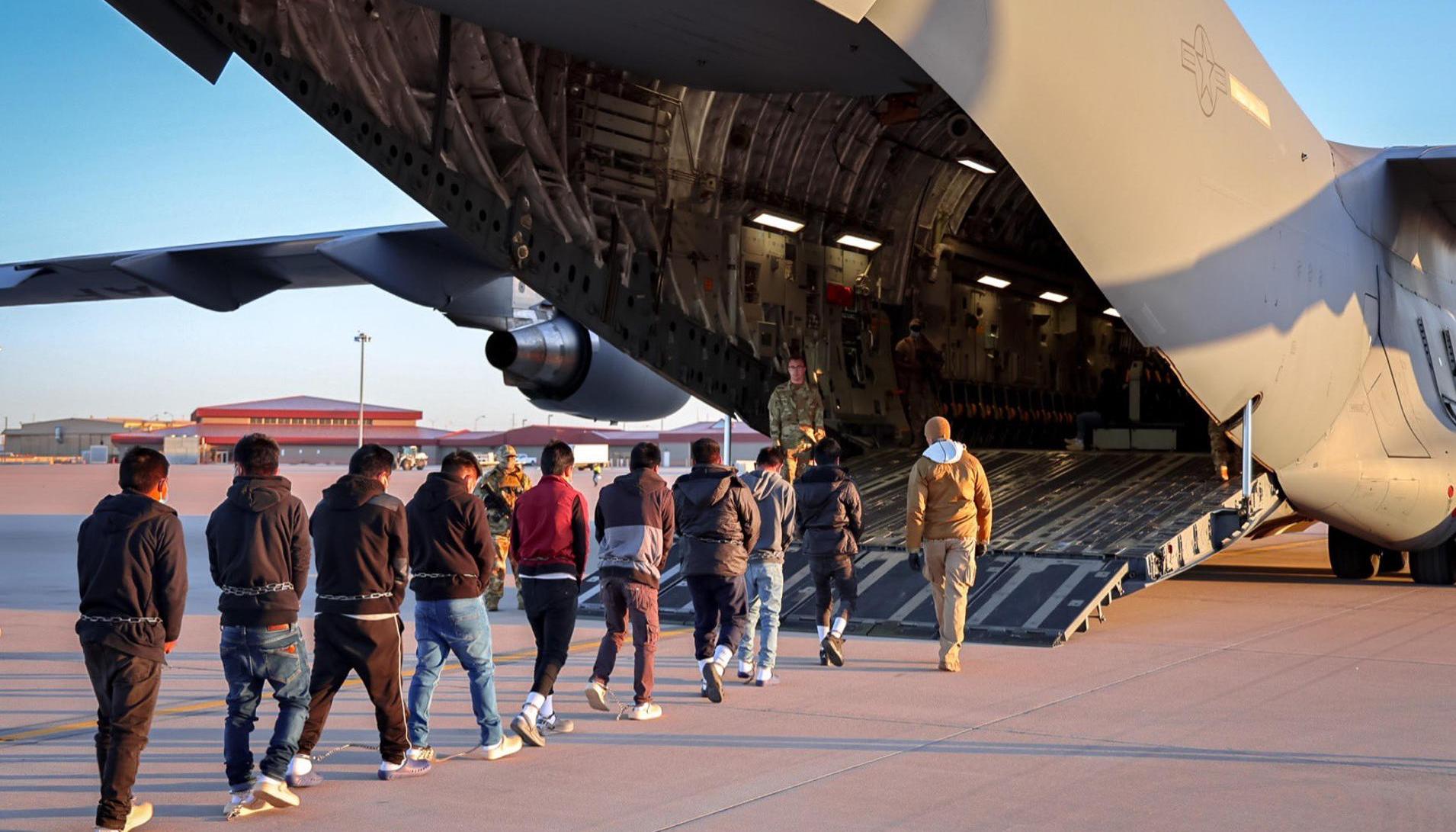 Inmigrantes ingresando a un avión para un vuelo de deportación.