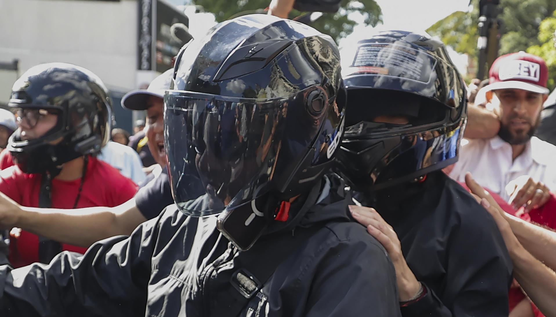María Corina Machado (de casco negro) retirándose de la manifestación de este jueves.