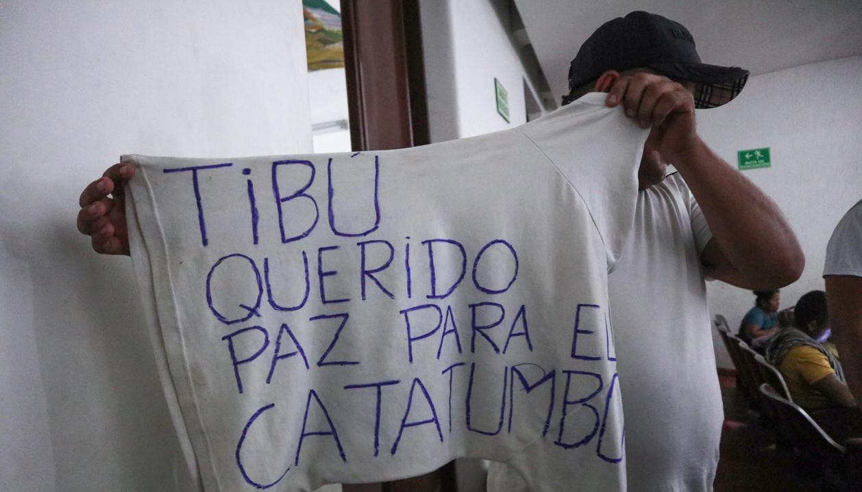 Un hombre desplazado por la violencia muestra una camiseta que pide paz para el Catatumbo.