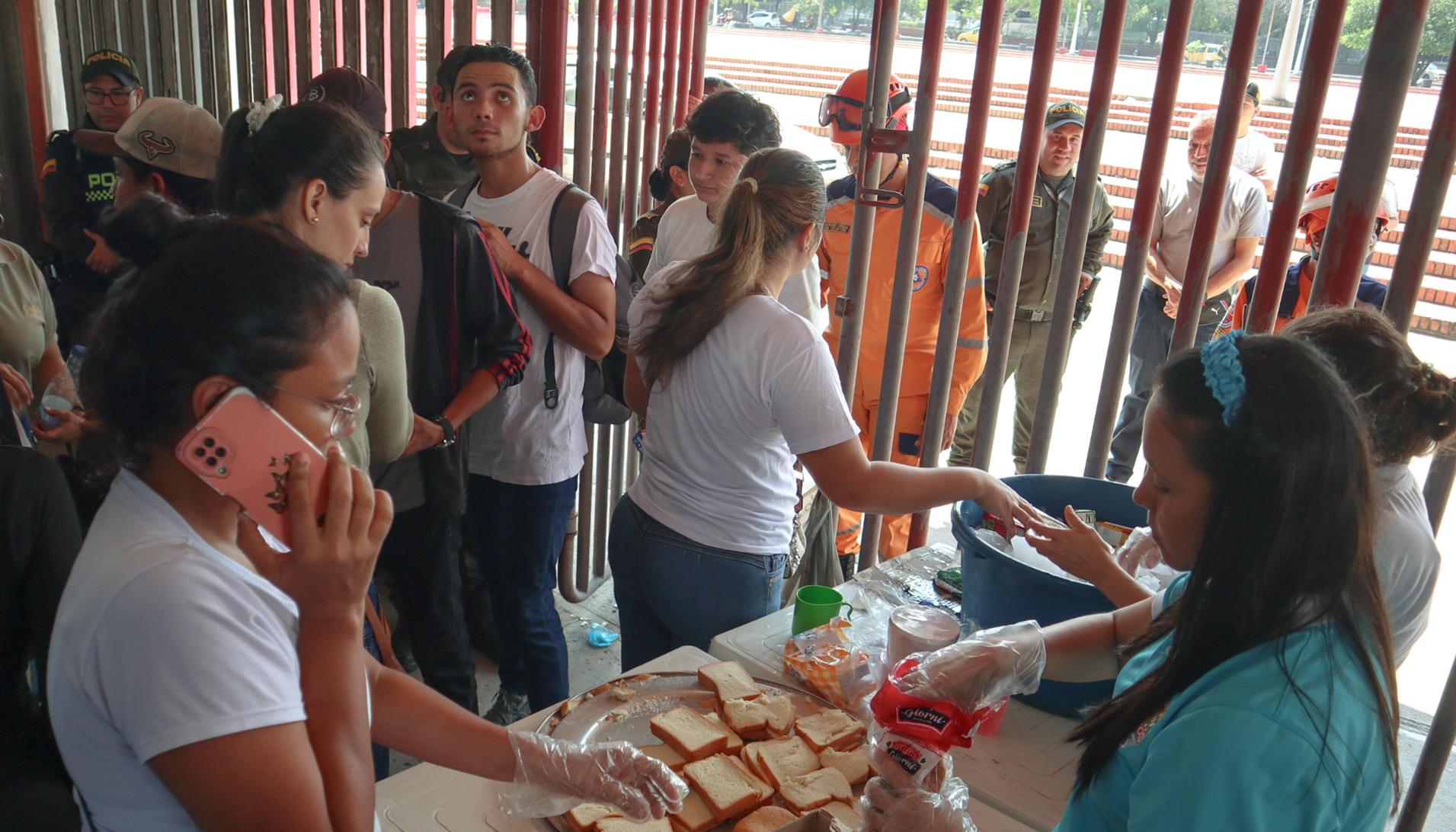 Personas desplazadas por la violencia en la región del Catatumbo reciben alimentos en el estadio General Santander. 