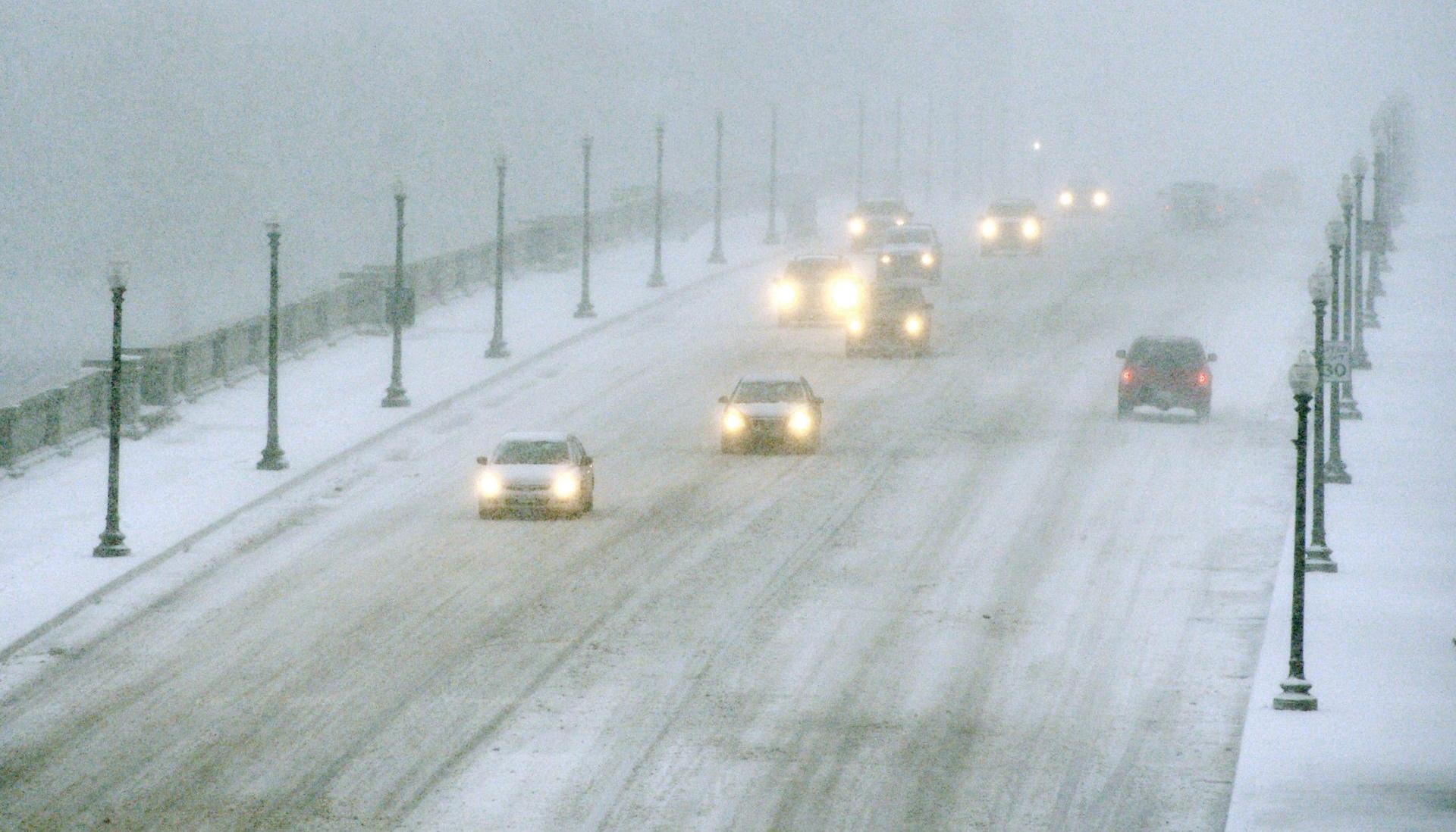 Vehículos avanzando en medio de la nieve en el Puente Memorial de Arlington que conecta a Virginia con Washington.