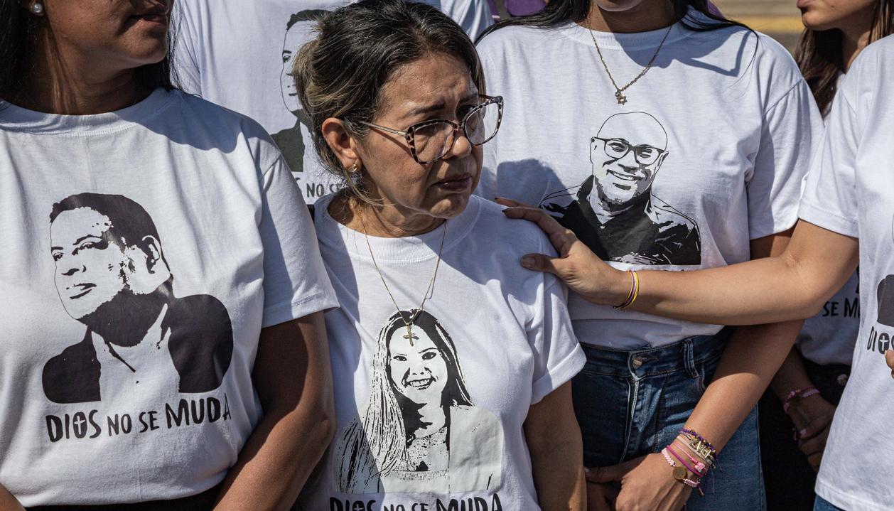 Personas portan camisetas con imágenes de sus familiares detenidos durante una manifestación.