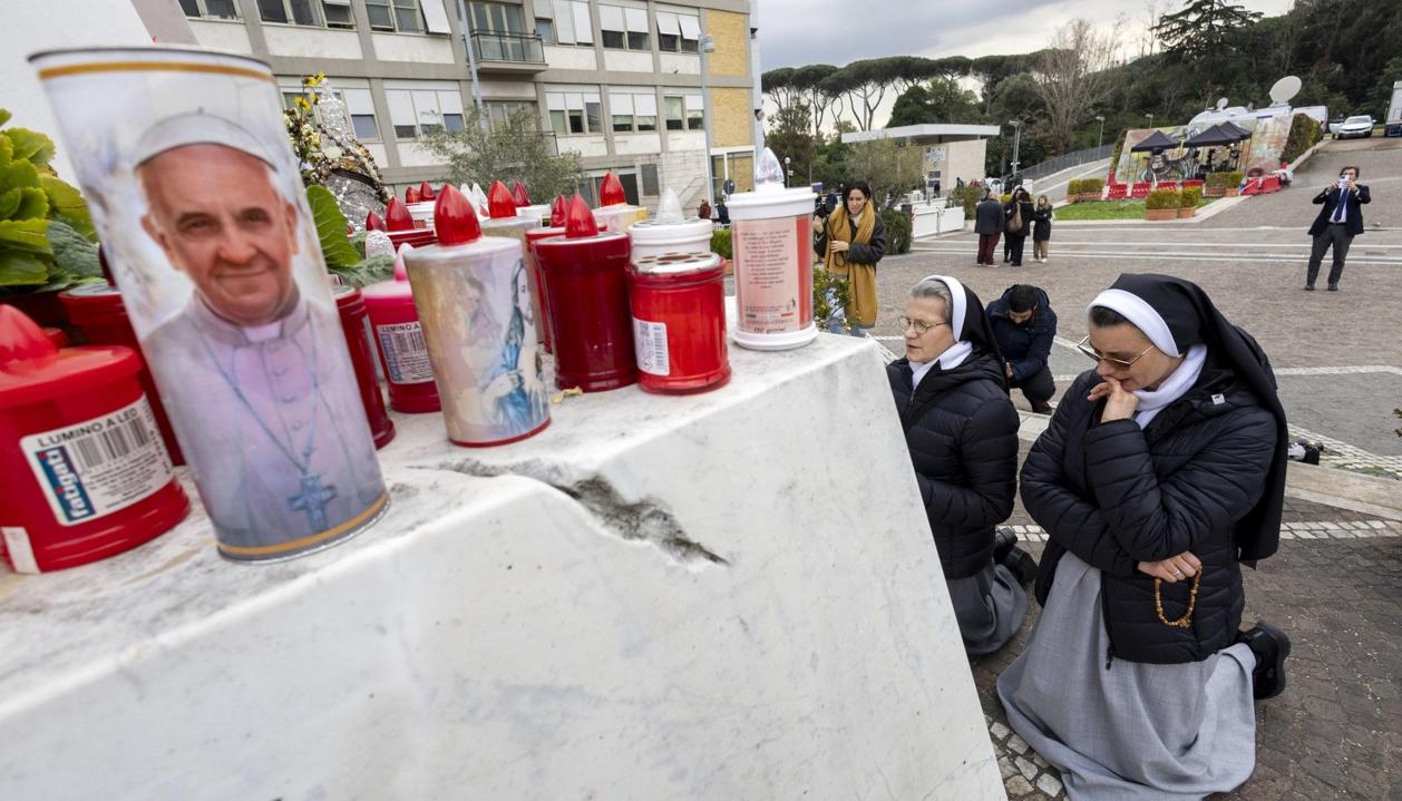 Dos monjas rezan bajo la estatua del Papa Juan Pablo II, en el policlínico Gemelli.