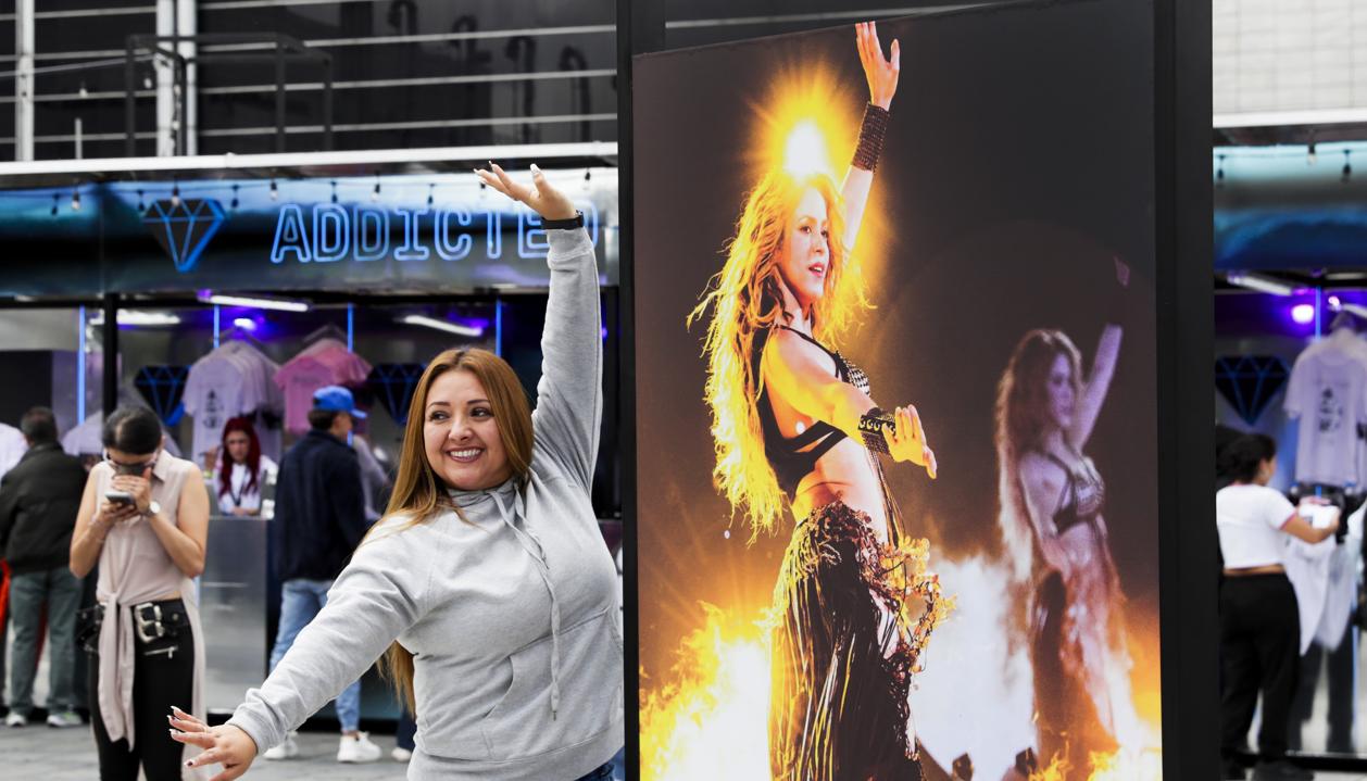 Una seguidora de Shakira posa junto a una foto de la cantante barranquillera. 