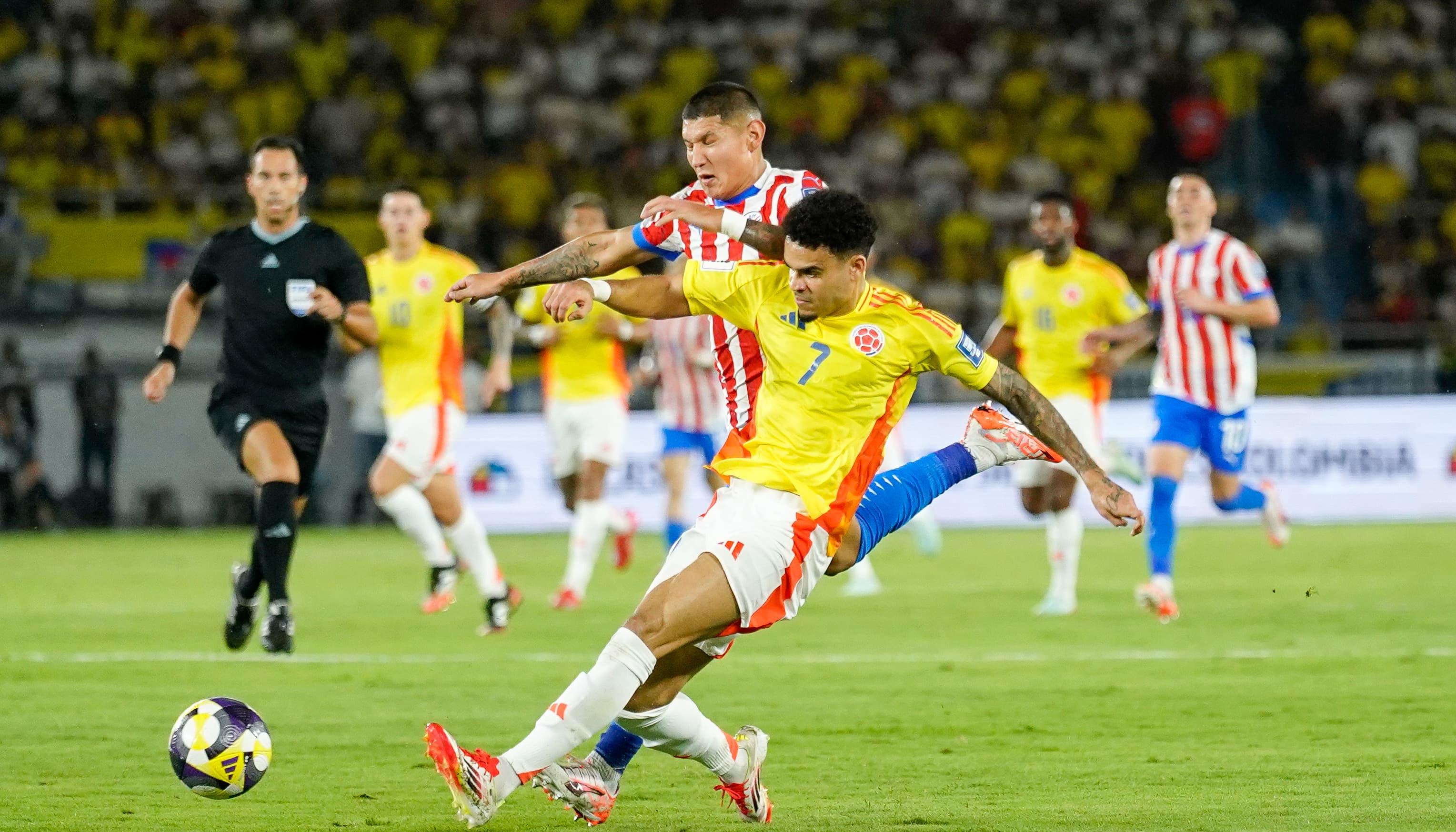 Luis Díaz en disputa del balón contra un rival paraguayo.