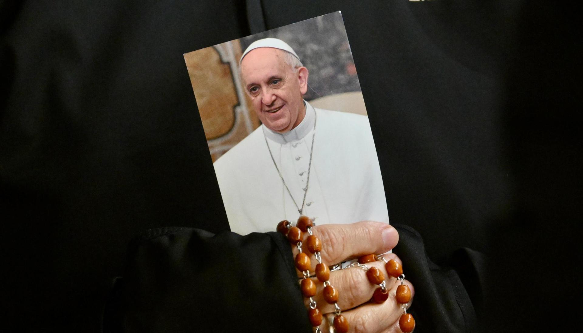 Una monja sostiene una imagen del Papa Francisco y un rosario.