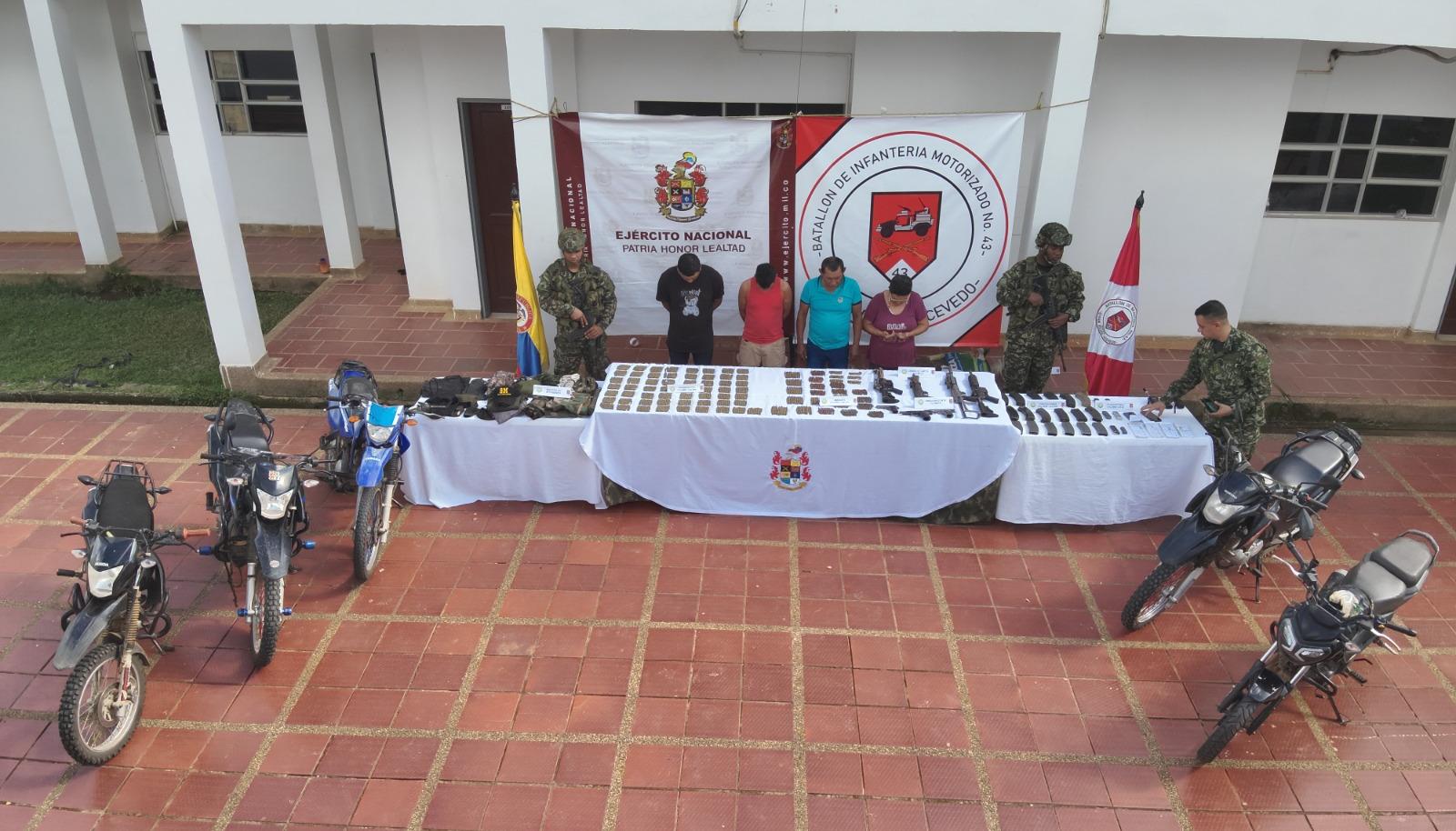 Cuatro de los capturados y armas incautadas. 