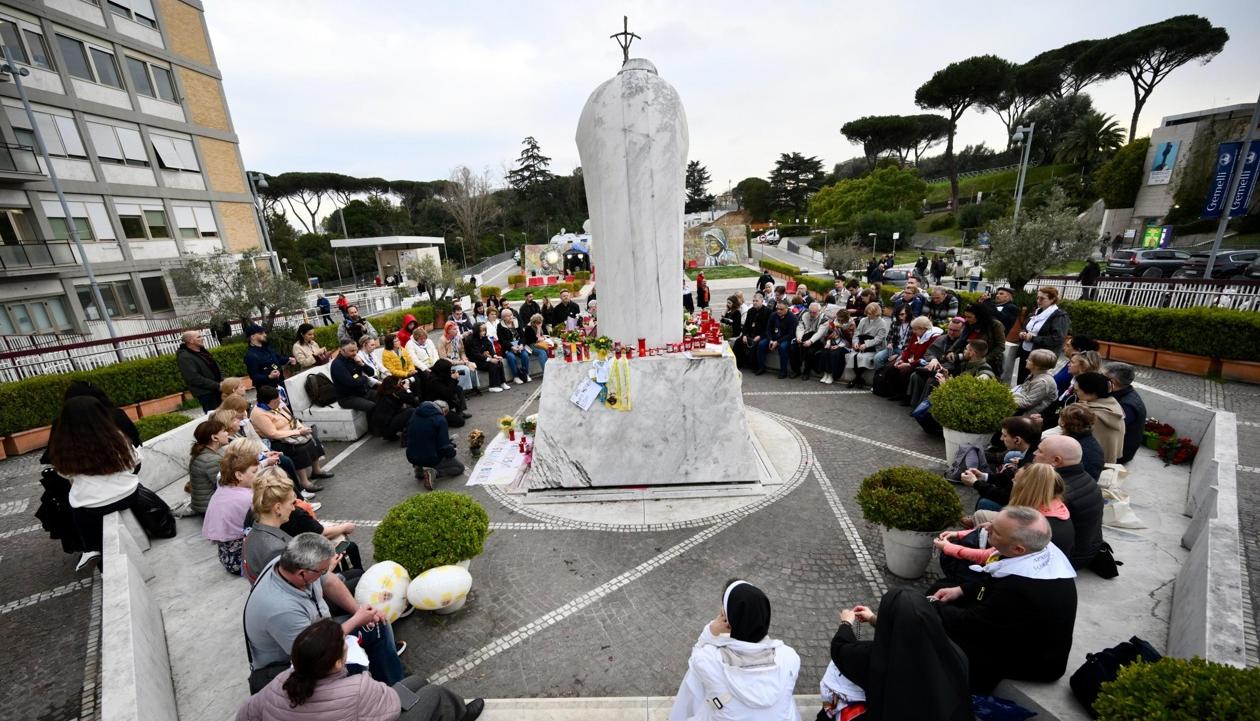 Un grupo de peregrinos rusos se reúne junto a la estatua de Juan Pablo II en la entrada del Hospital Gemelli.