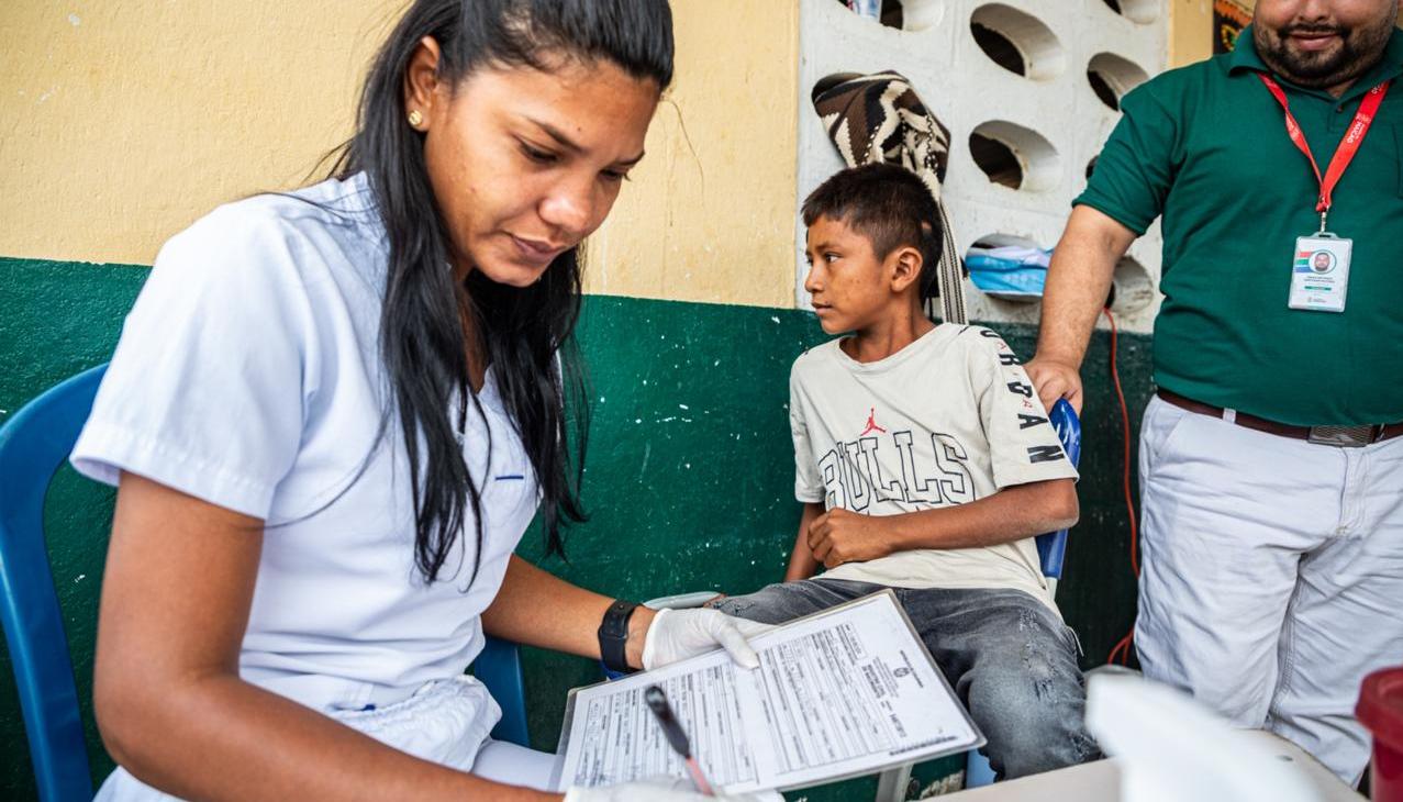 Funcionaria de la Registraduría realizando un registro civil a un miembro de la comunidad Wayúu. 