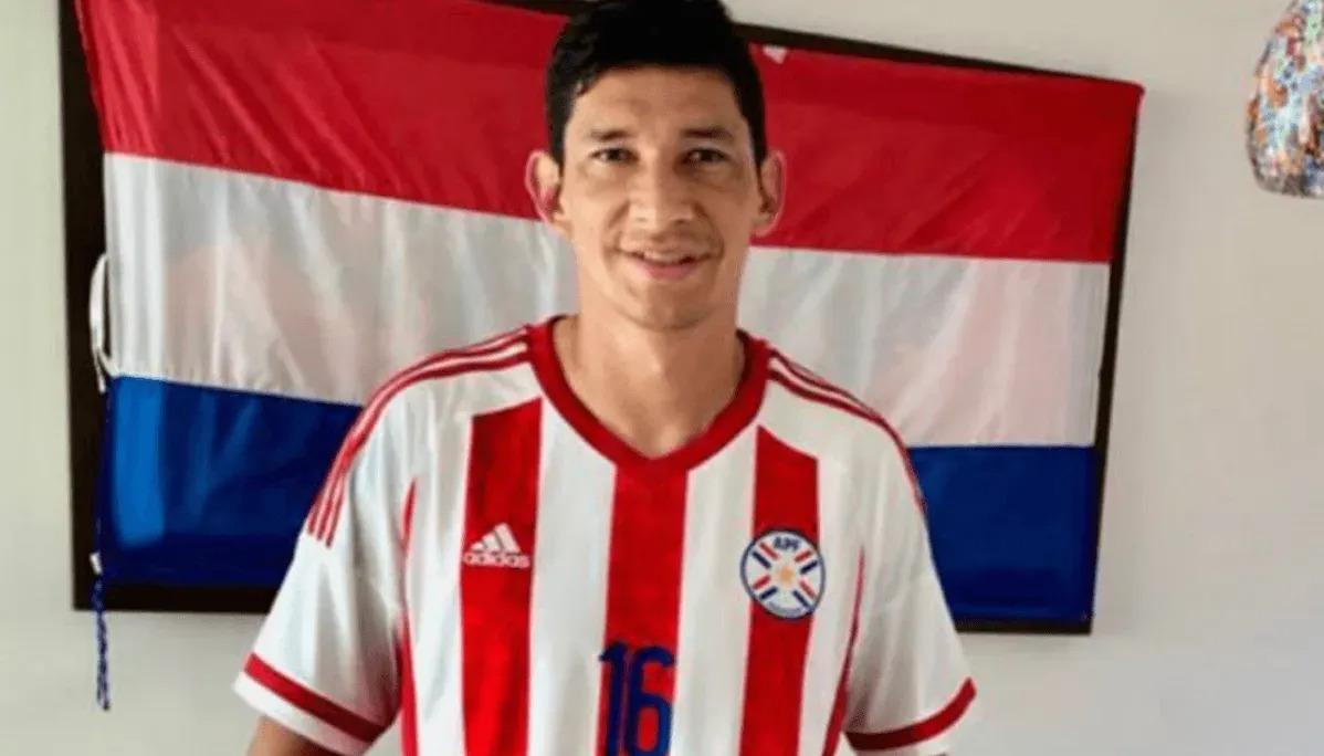 Roberto Ovelar con la camiseta y bandera de la selección paraguaya.