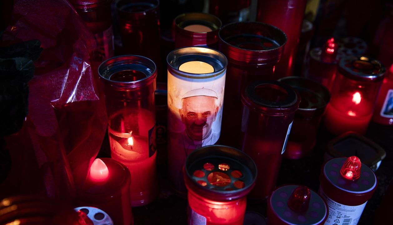 Velas encendidas frente a la estatua de Juan Pablo II a la entrada del hospital Gemelli.