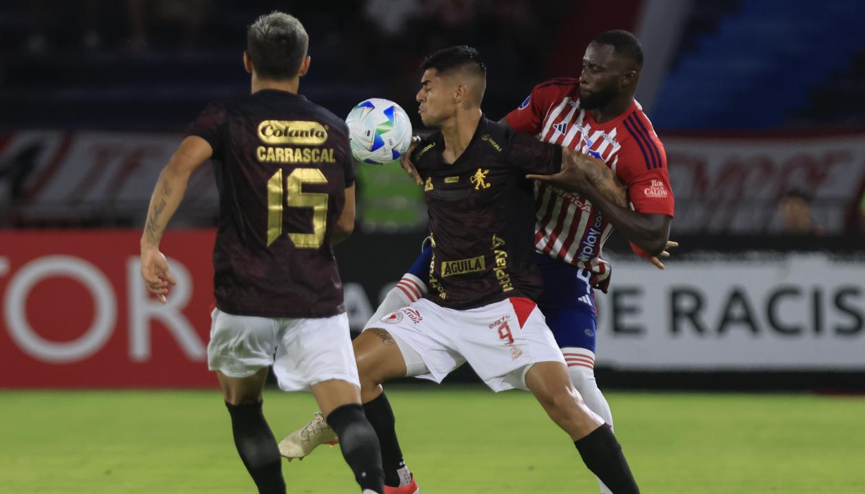 José Cuenú disputa la pelota con el delantero peruano Luis Ramos. 