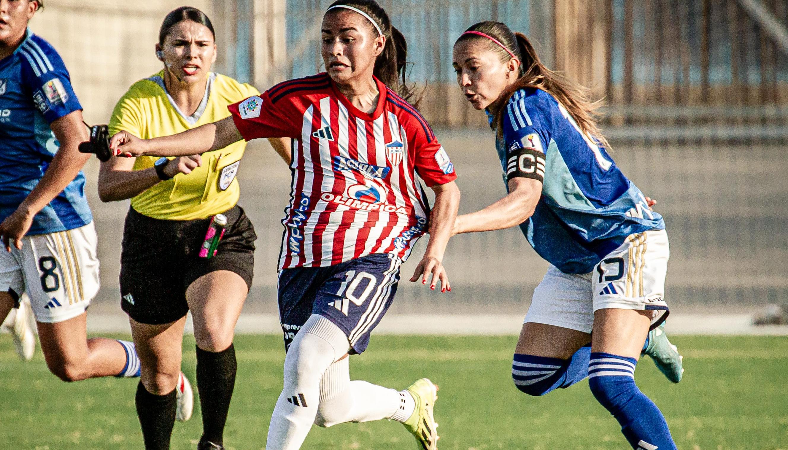 Wesly Rodríguez avanza con la marca de una jugadora de Millonarios.