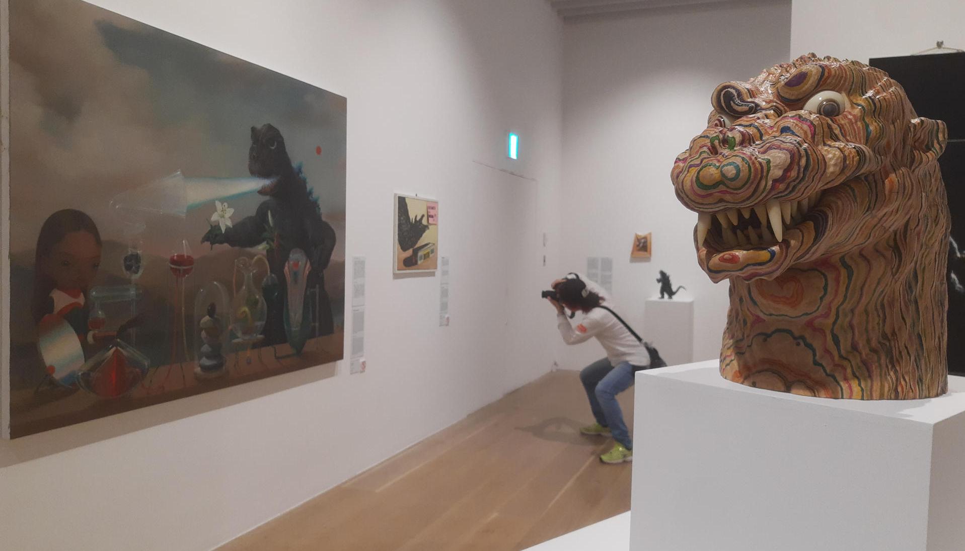 Un hombre fotografía algunas de las obras de la exposición 'Godzilla the Art'.