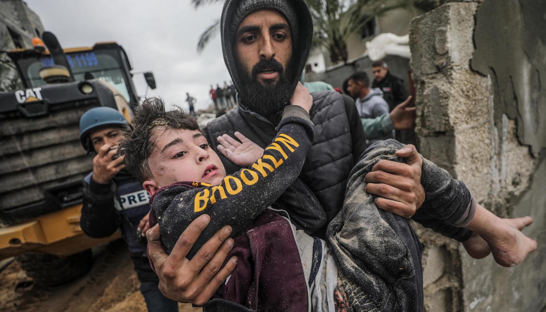 Los palestinos recuperan a un niño herido de debajo de los escombros.