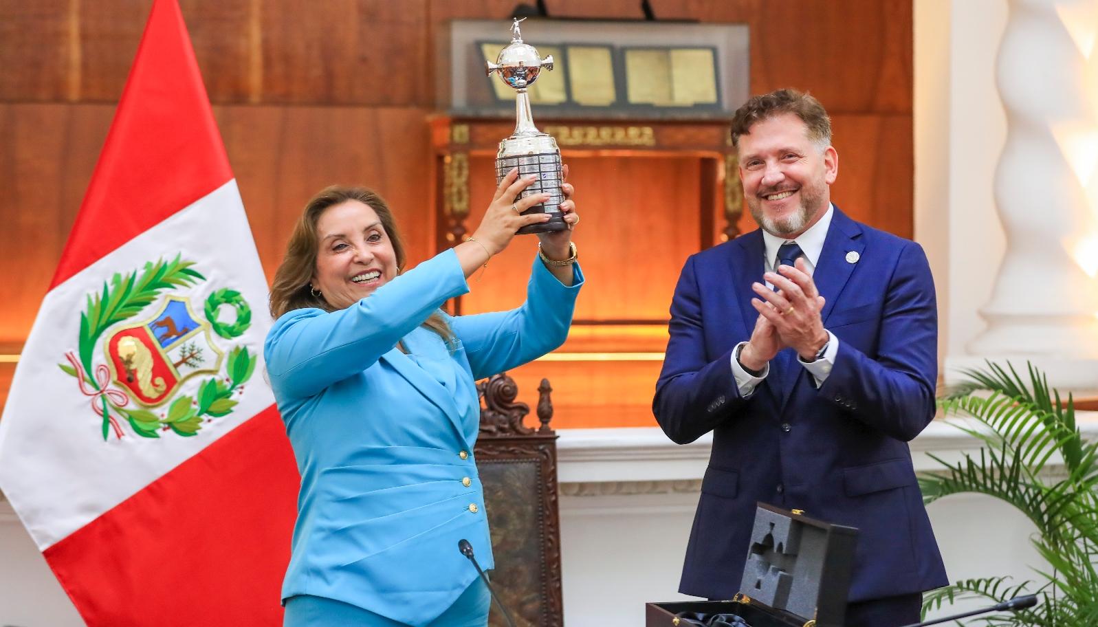 Dina Boluarte, presidenta de Perú, con el trofeo de la Copa Libertadores. A su lado, Alejandro Domínguez, titular de la Conmebol. 