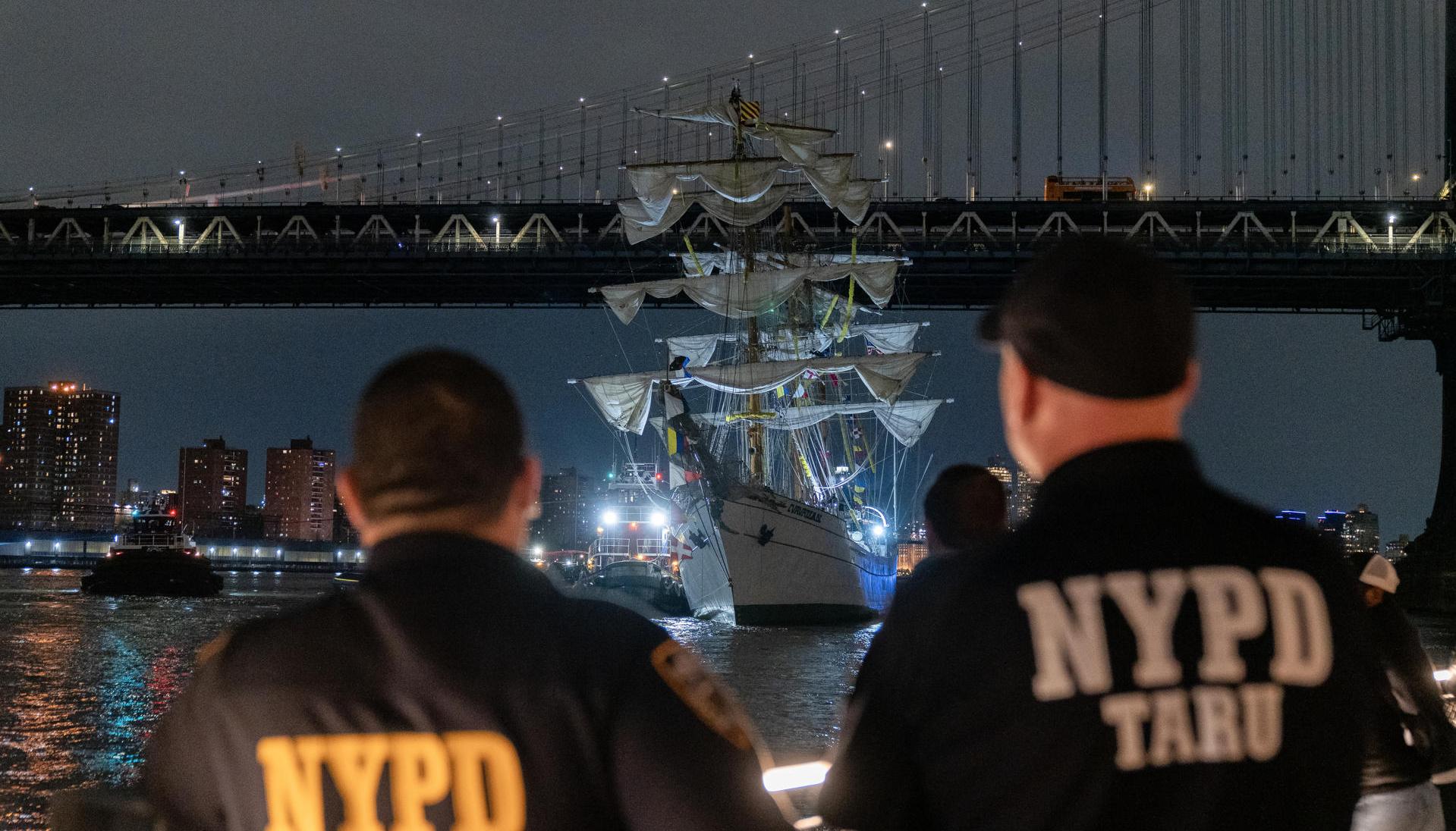 Integrantes del departamento de Policía de Nueva York observan el buque escuela mexicano Cuauhtémoc junto al puente de Brooklyn.