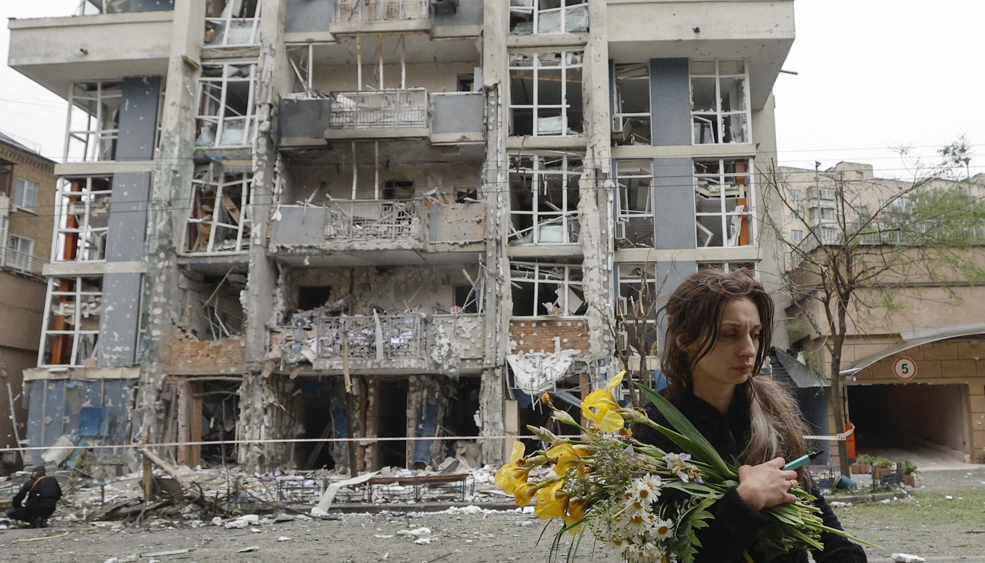 Mujer caminando junto a un edificio destruido tras el ataque nocturno. 