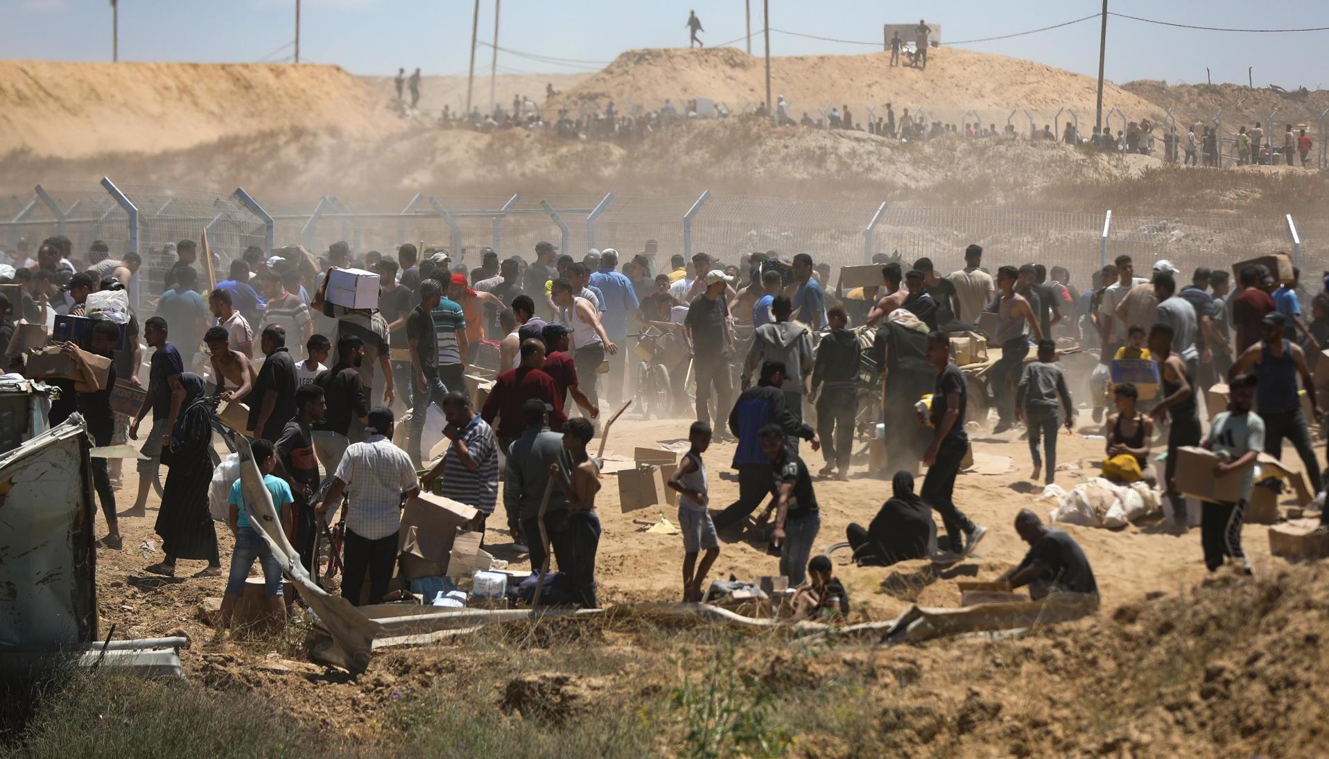 Palestinos transportan suministros de ayuda recibidos de la Fundación Humanitaria de Gaza.