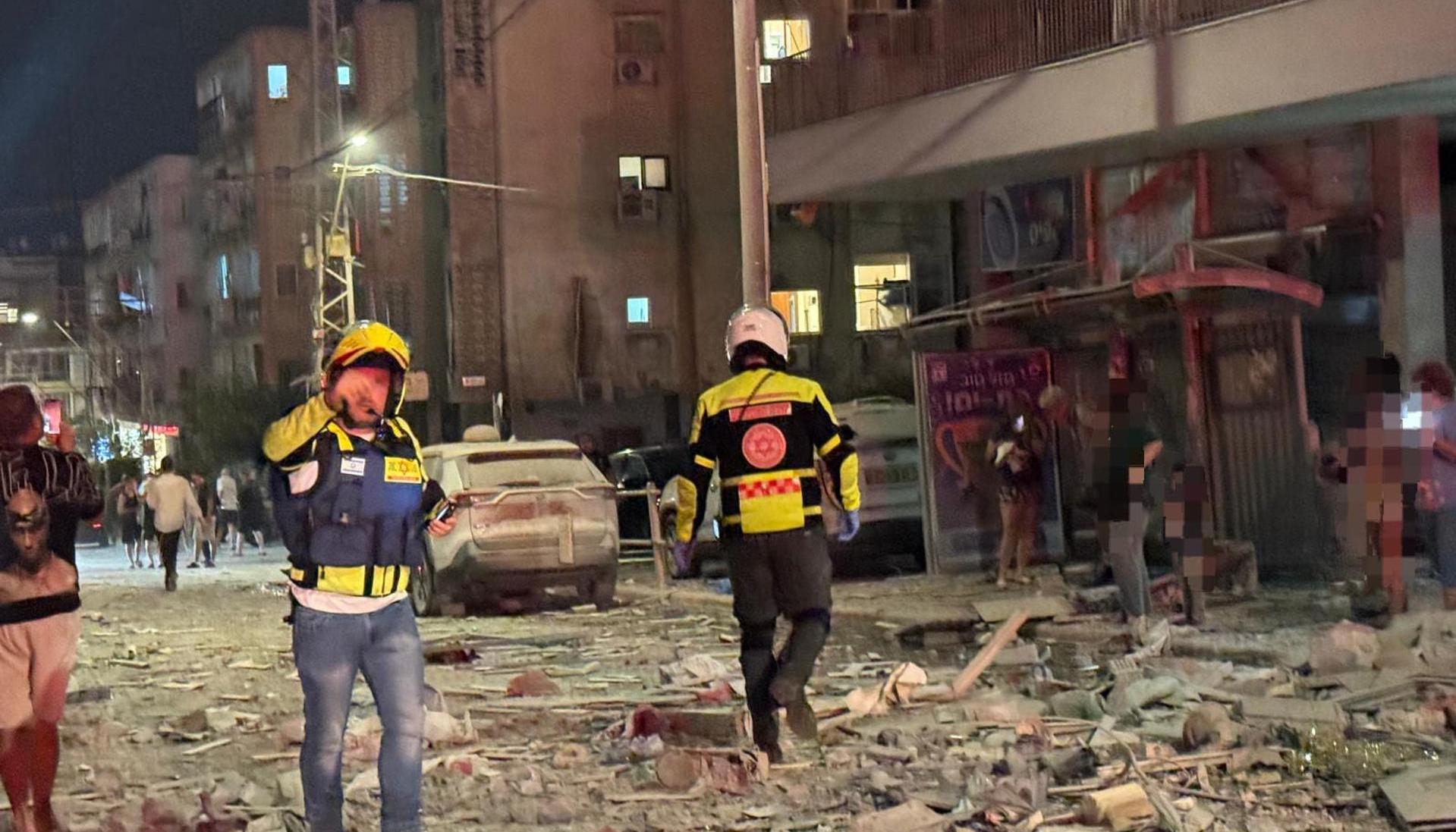 Integrantes de equipos de emergencia, bomberos y policía, trabajan en el área donde un proyectil iraní.