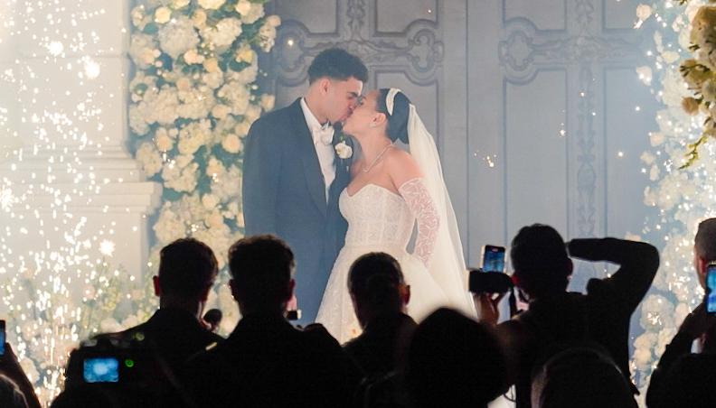 La pareja dándose un beso en las afueras de la iglesia.