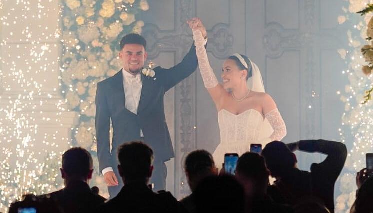 Luis Díaz y Geraldine Ponce alzando los brazos después de su boda.