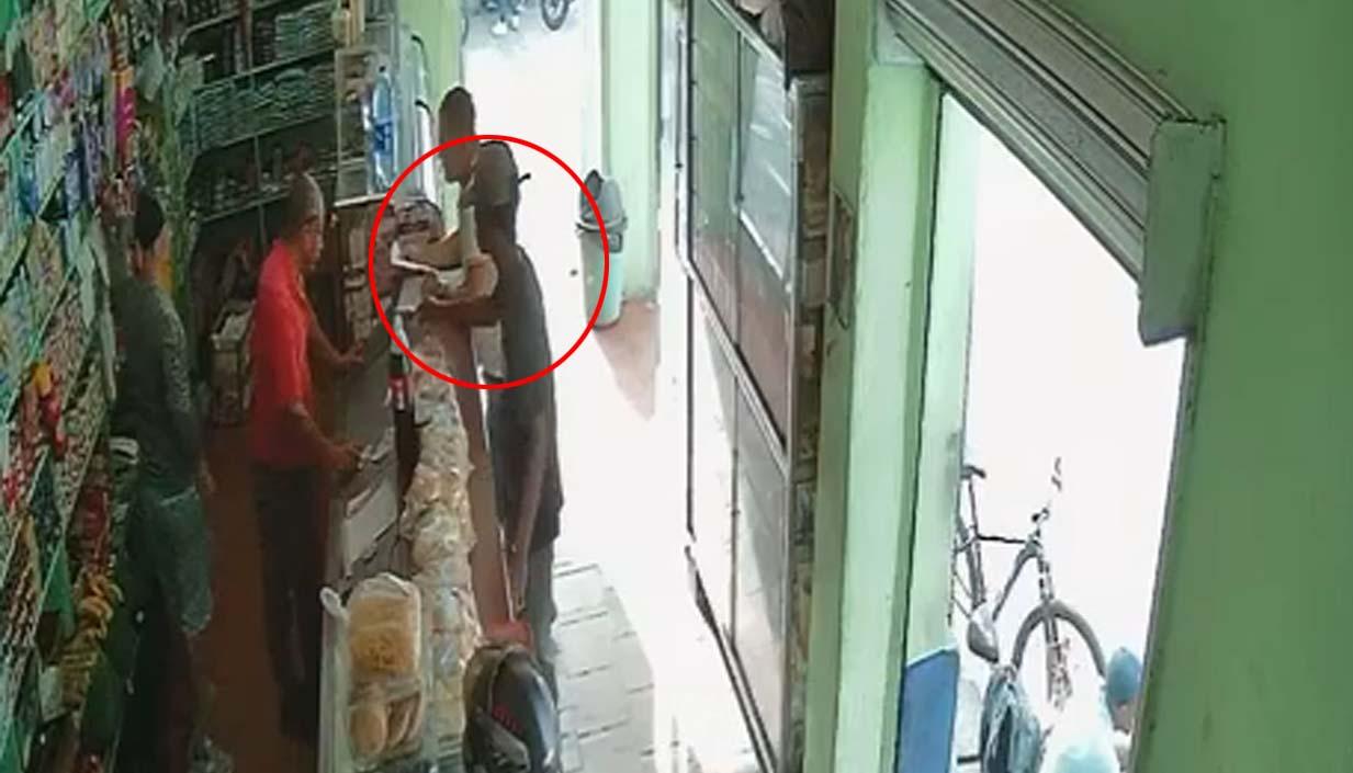 Momentos en que el joven dejaba un panfleto en una tienda en la tarde