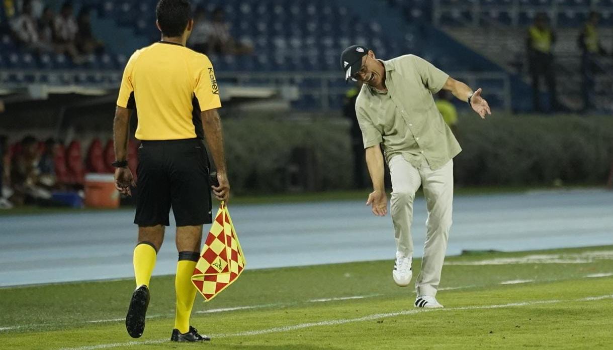 El técnico del Junior, Alfredo Arias, le reclama una jugada al árbitro asistente. 