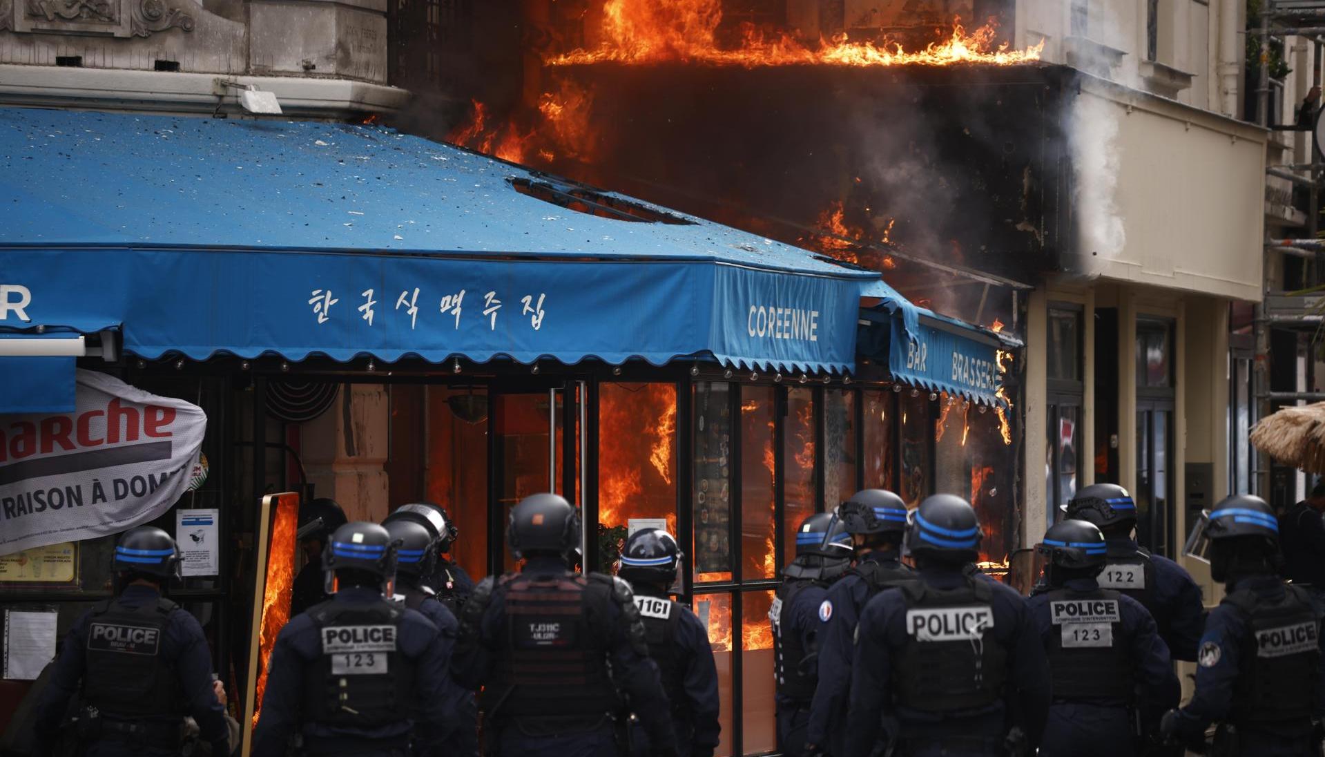 Agentes de policía aseguran alrededor de un restaurante en Paris tras ser incendiado.