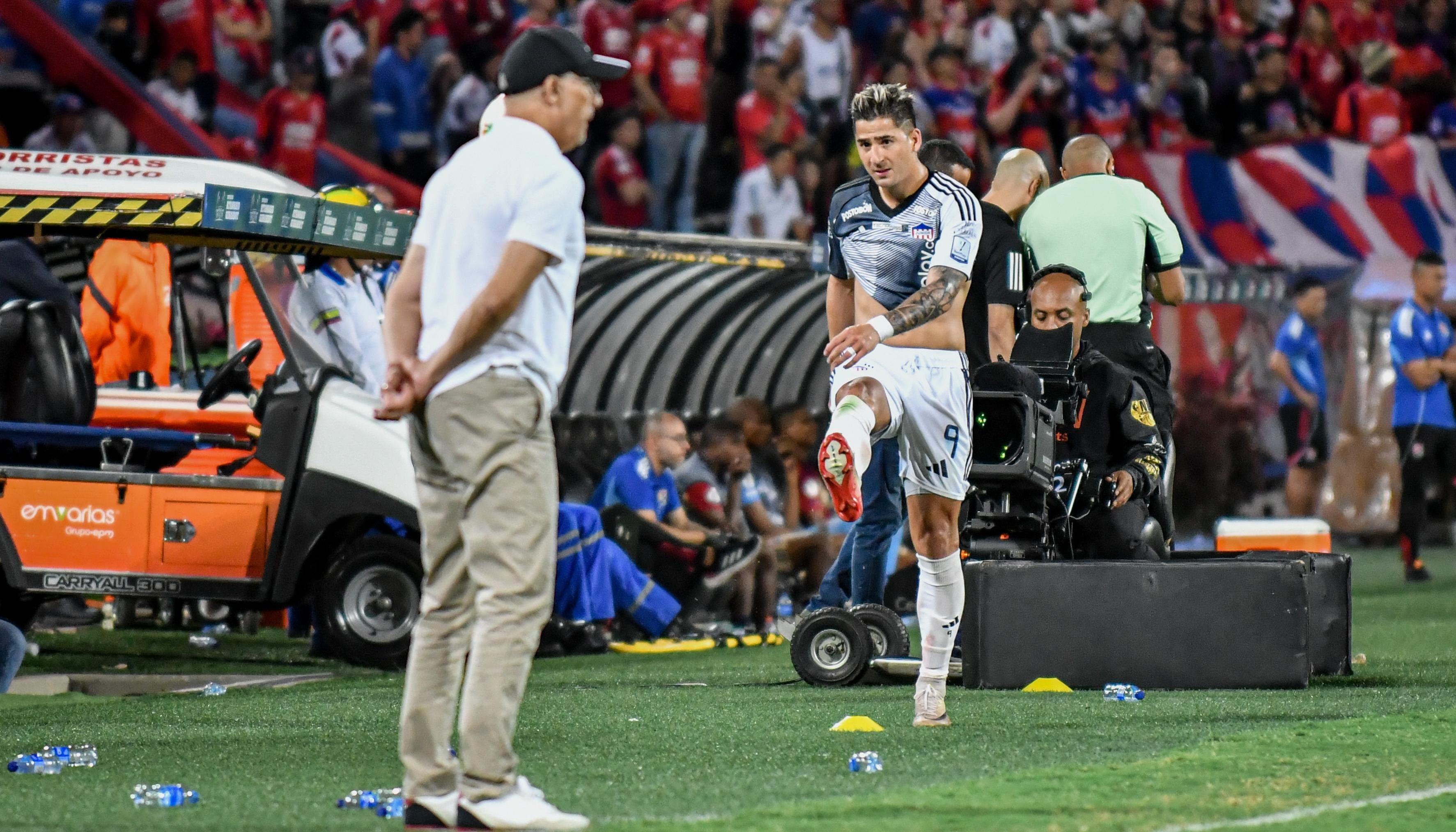 Guillermo Paiva se acerca al técnico Alfredo Arias tras ser sustituido en el partido contra el Medellín.