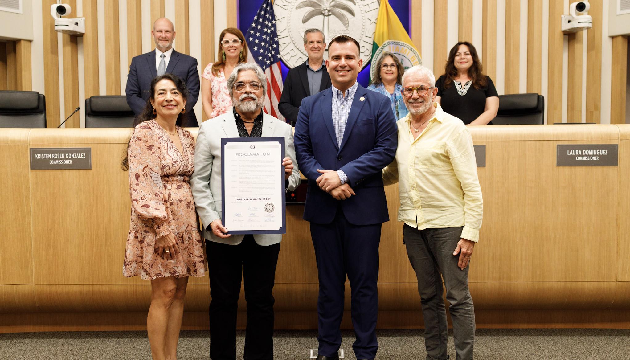 La poeta y periodista Claudia Rosenow, el escritor Jaime Cabrera González, el comisionado Alex Fernández y el gestor cultural Ray Breslin. Detrás, el alcalde Steven Meiner y los comisionados.