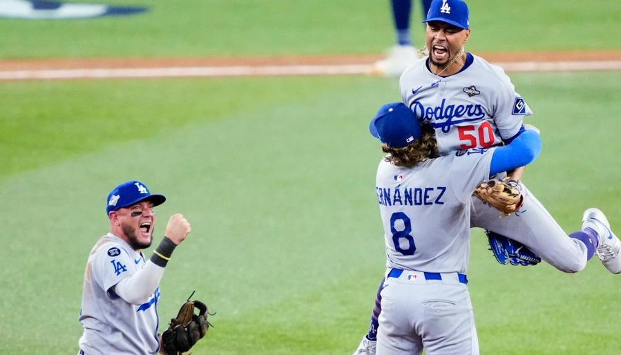 Mookie Betts, Kiké Hernández y Miguel Rojas celebran tras sacar el último out del juego. 