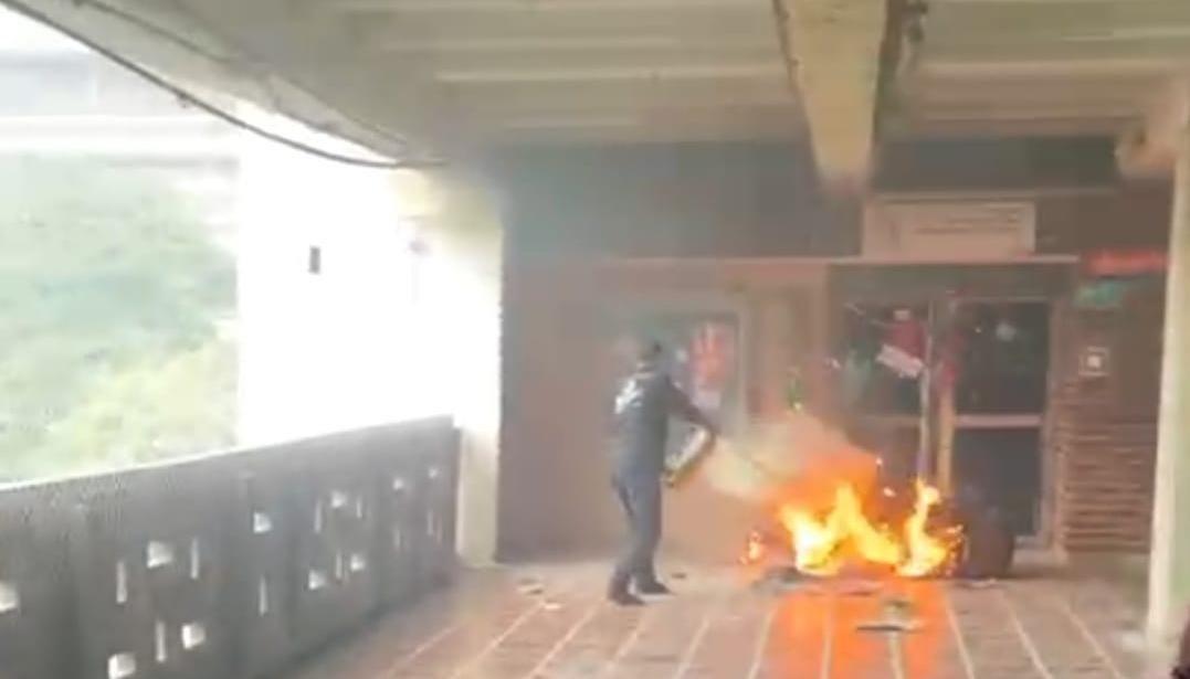 Personal de Uniatlántico mientras controla el incendio con un extintor.