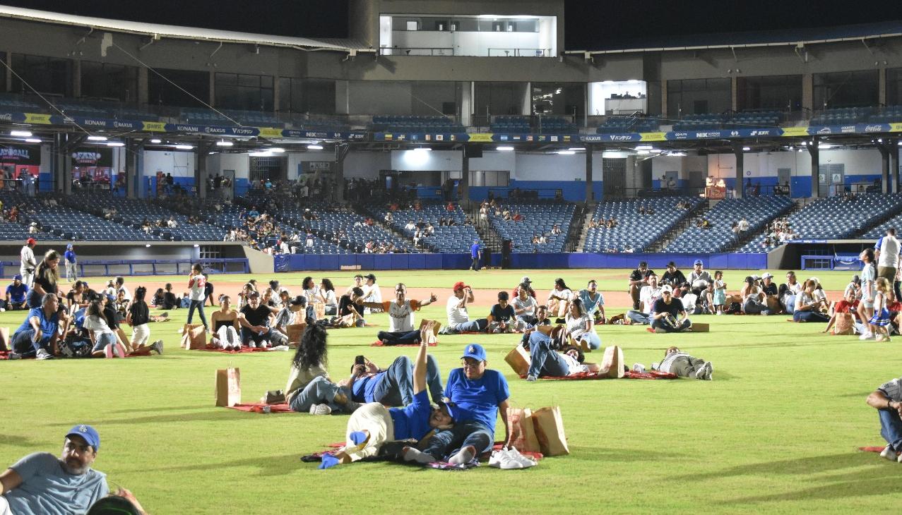 Aficionados en el terreno del juego del Édgar Rentería disfrutando de 'Picnic en el Diamante'.