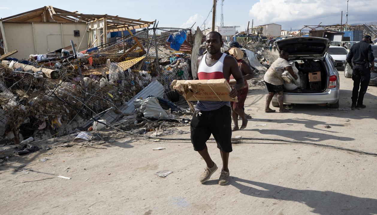Personas afectadas por el paso del huracán Melissa recolectan objetos en Black River (Jamaica).