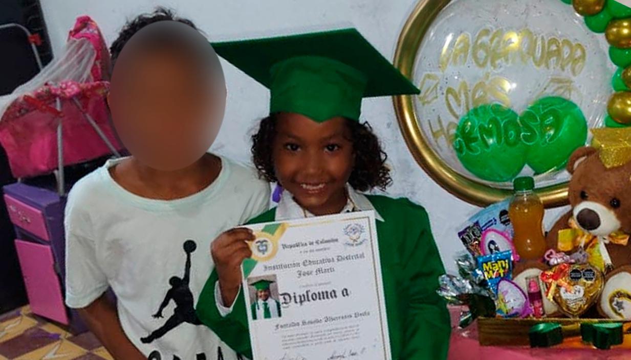 La niña con su diploma de grado y al lado de su hermanito.