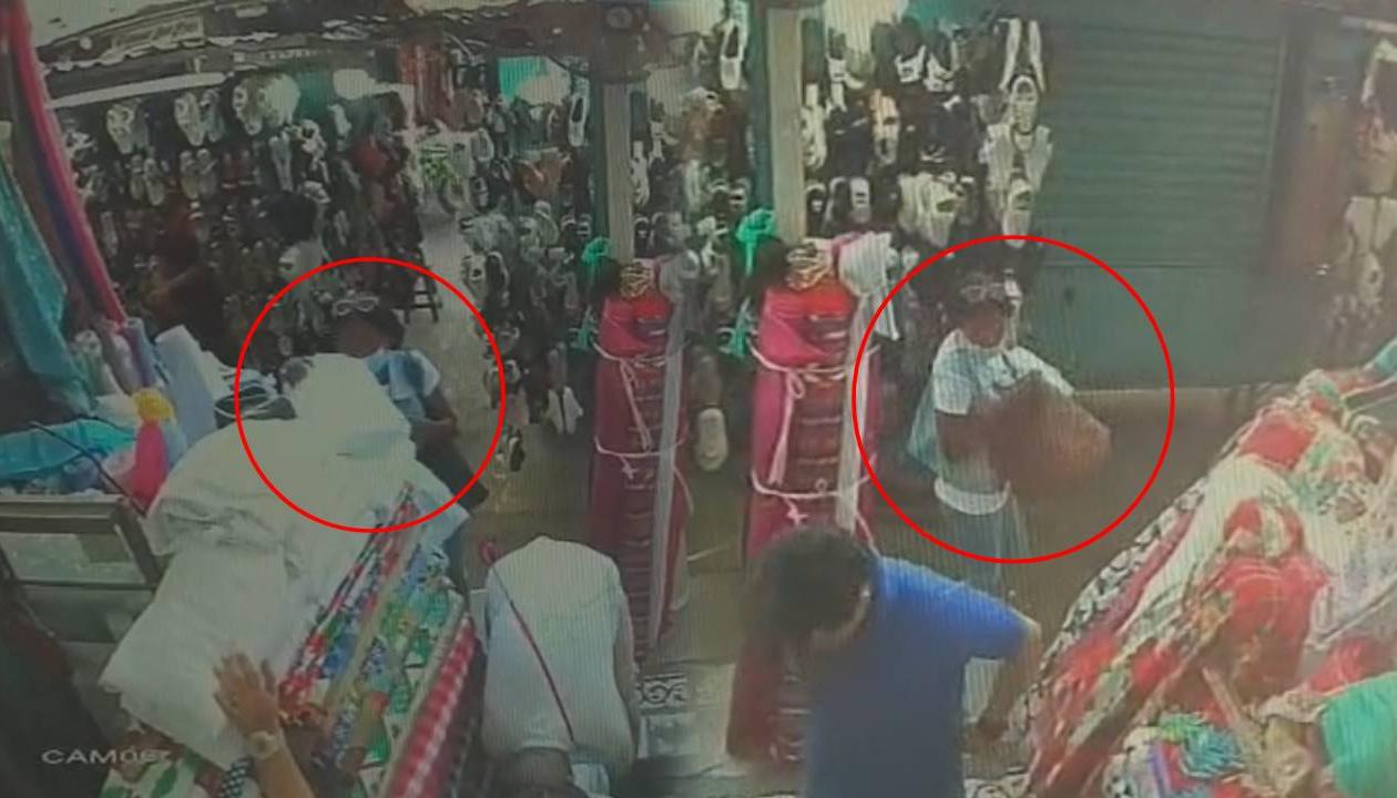 Momento en que mujer roba las dos telas.