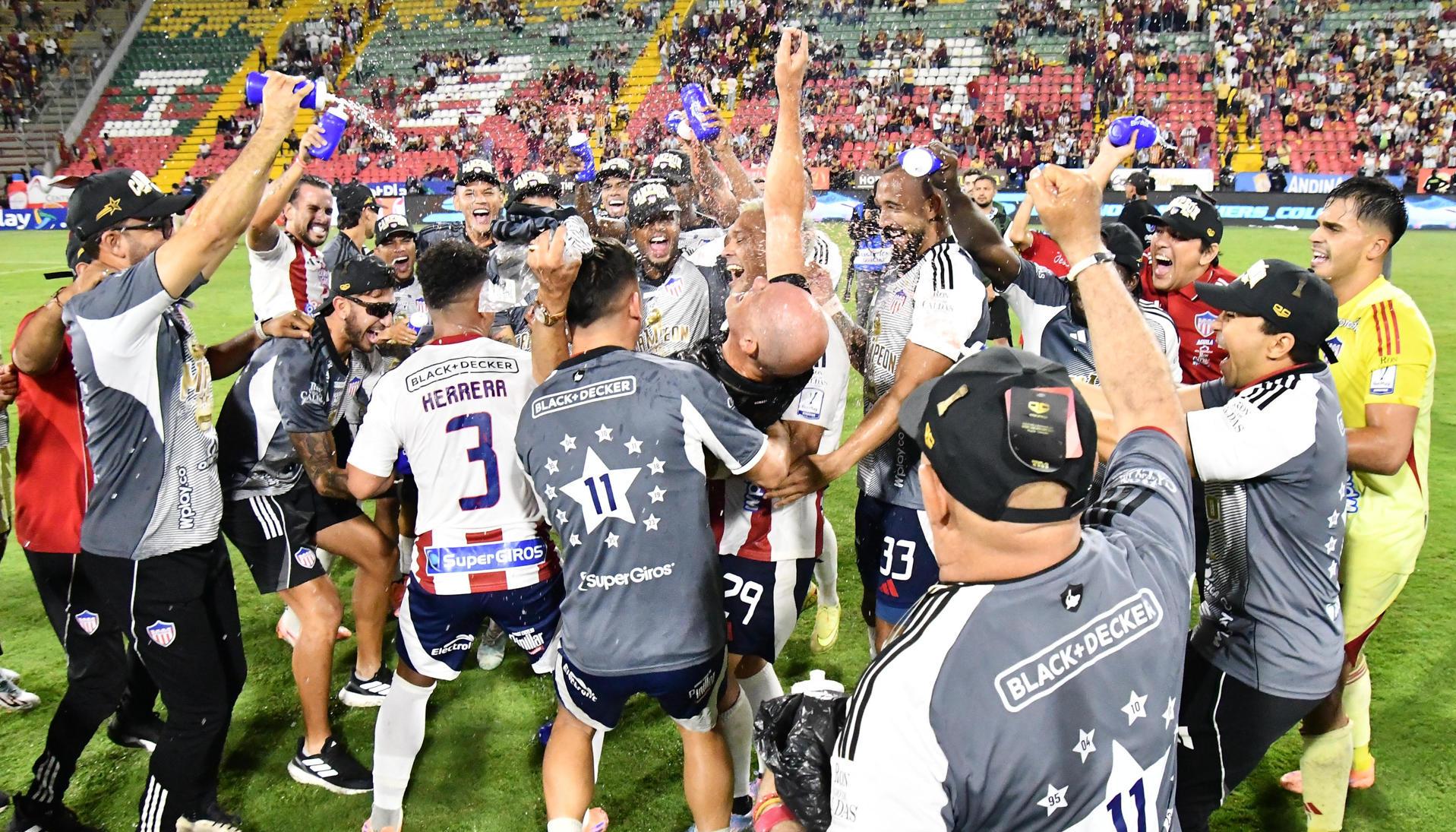 El técnico del Junior, Alfredo Arias, celebra el título con sus jugadores.