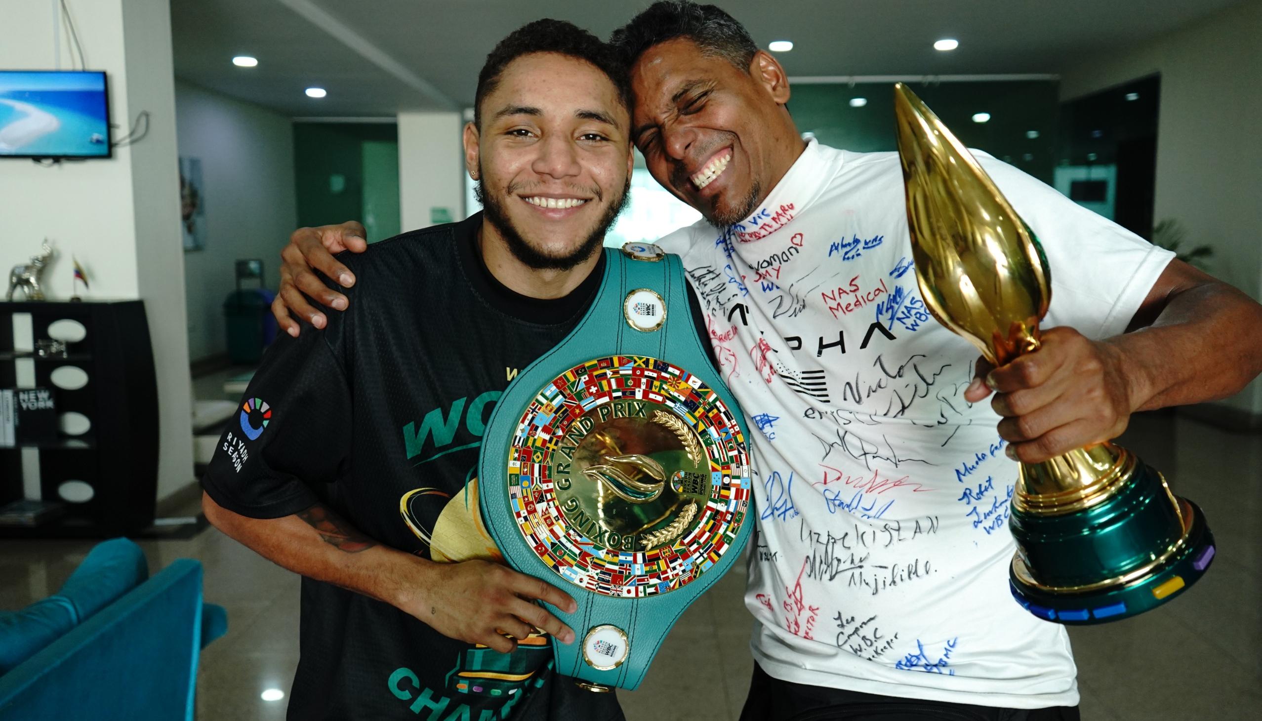 Carlos Utria con el cinturón de campeón y su papá y entrenador Lenin 