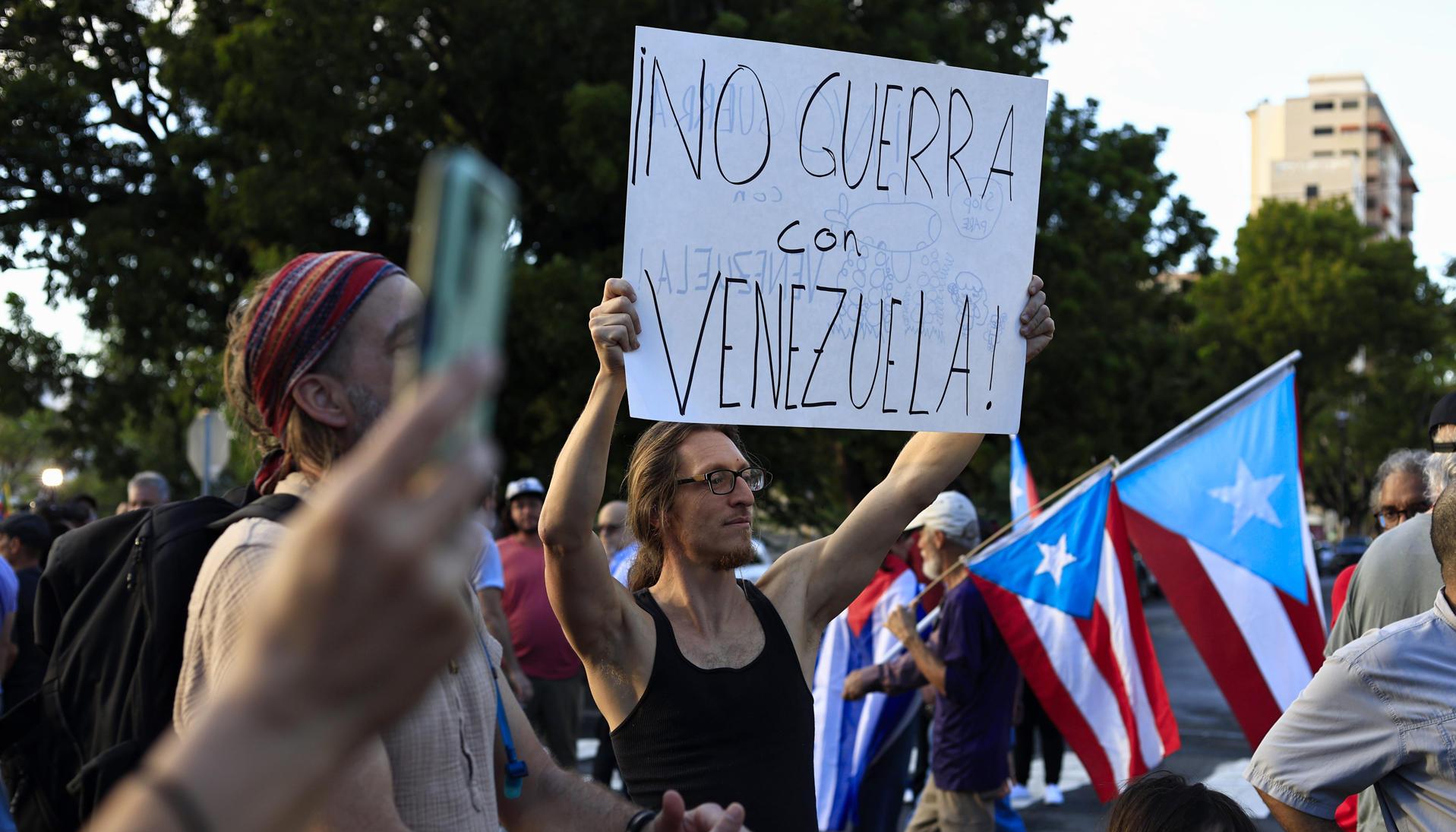 Un hombre sostiene un cartel durante una manifestación en apoyo a Venezuela en Puerto Rico. 