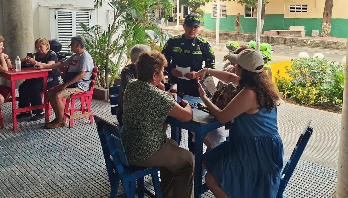 Uniformados de la Policía con visitantes en el Museo del Carnaval. 