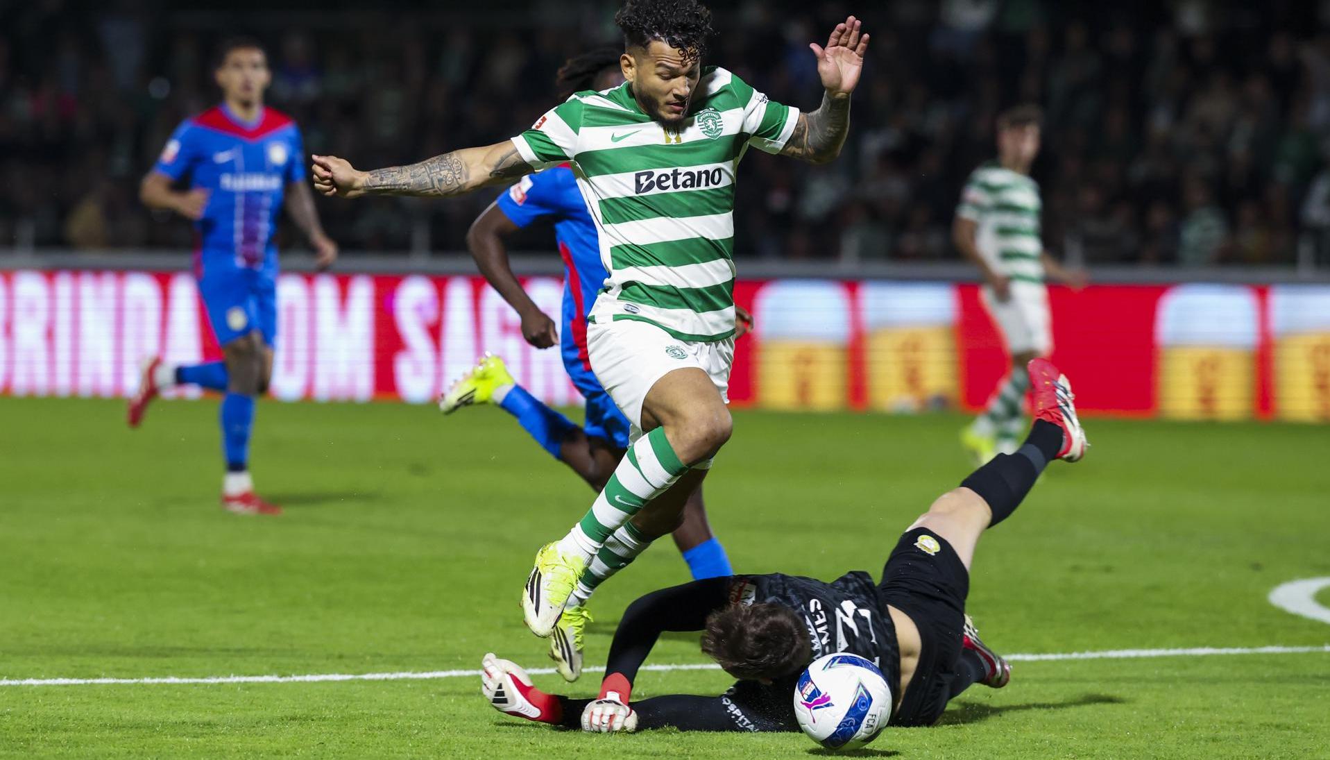 El portero del Alverca André Gomes trata de frenar al delantero del Sporting Luis Suárez.