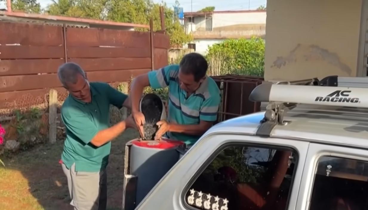 El cubano colocando el carbón para que el vehículo funcione. 